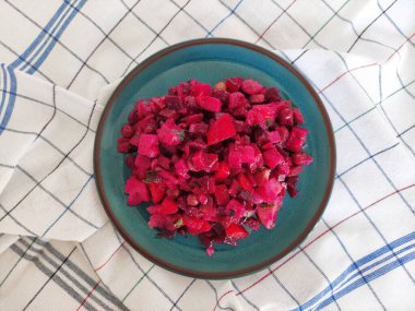 Pancar köklü lezzetli Rus kırmızı sebze salatası, mavi seramik tabakta salata.