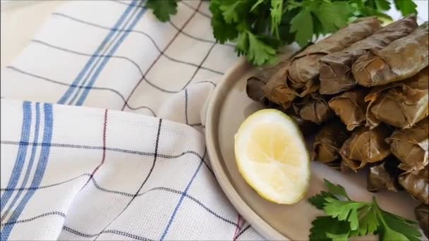 传统的东方土耳其洋娃娃 由盛满米饭和肉的葡萄叶制成 放在放有欧芹和柠檬片的盘子里 — 图库视频影像