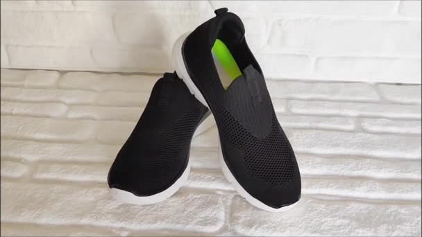 Μαύρο Ύφασμα Αθλητικά Sneakers Άσπρες Σόλες Λευκό Φόντο Τούβλο — Αρχείο Βίντεο