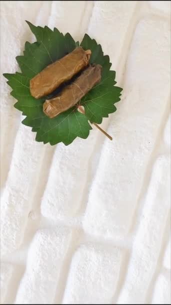 美味的传统东方土耳其洋娃娃 由葡萄叶制成 里面塞满了米饭和白砖背景的绿叶 — 图库视频影像