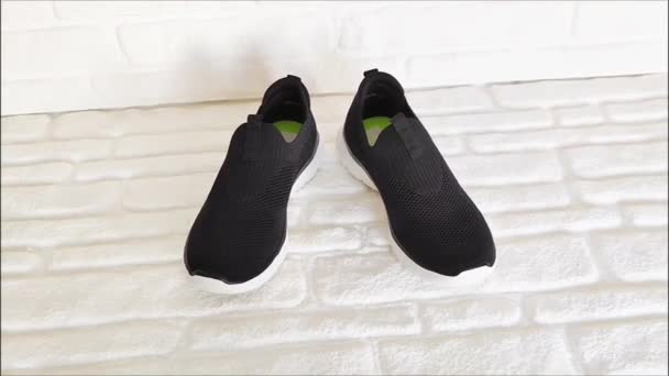 Zapatillas Deportivas Tela Negra Con Suelas Blancas Sobre Fondo Ladrillo — Vídeo de stock