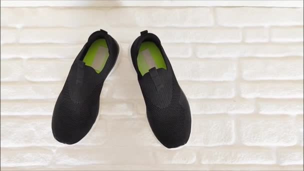 Zapatillas Deportivas Tela Negra Con Suelas Blancas Sobre Fondo Ladrillo — Vídeo de stock