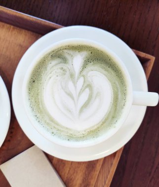 Beyaz metal bardakta yeşil köpüklü oryantal kibrit çayı.