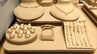 Çeşitli altın kadın mücevherleri, kolyeler, yüzükler, bilezikler vitrinde.
