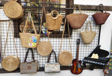  Bir sokak dükkanının vitrininde kadın çantaları örüyordu.