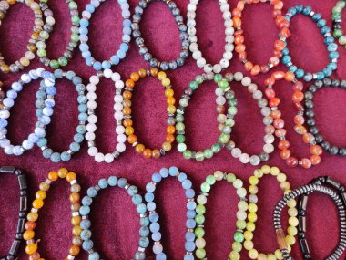  Çok renkli yuvarlak boncuklardan yapılmış bileklikler.