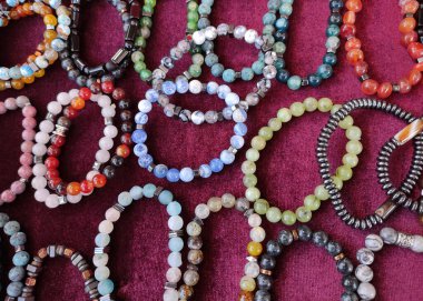  Çok renkli yuvarlak boncuklardan yapılmış bileklikler.