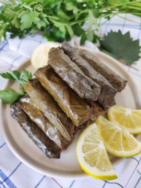Traditional oriental Turkish dolma made of grape leaves stuffed with rice on a decorative plate clipart