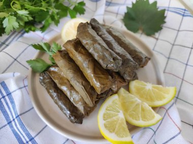 Dekoratif bir tabakta pirinçle doldurulmuş üzüm yapraklarından geleneksel Türk dolması