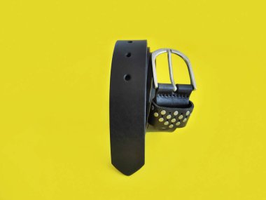 Sarı arka planda metal tokalı kadın derisi siyah kemer.