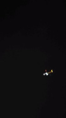 Gece gökyüzünde bir jet uçağı hızla uçuyor.