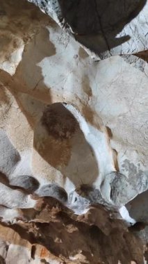 İlkel insanların yaşadığı, duvarları olan bir kaya mağarasının içinde.