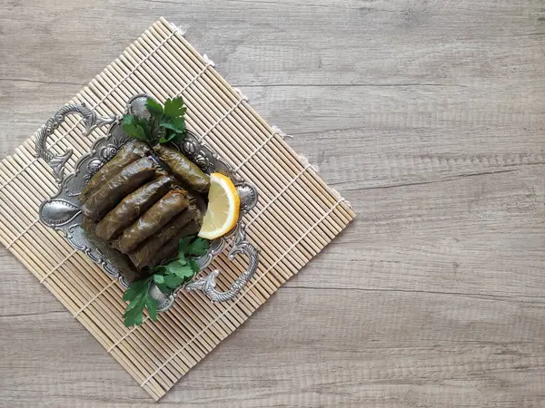 Stock image Oriental delicious Turkish dolma made of grape leaves stuffed with rice on a ceramic plate