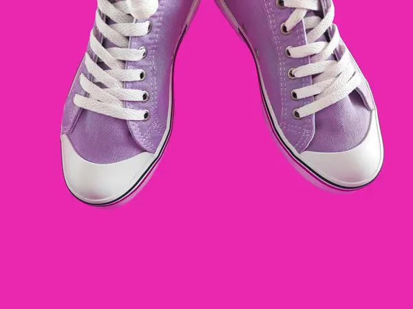 stock image  Purple sports sneakers with white laces on a pink background