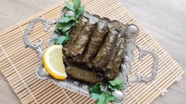 Dekoratif bir tabakta pirinçle doldurulmuş üzüm yapraklarından yapılmış lezzetli bir Türk dolması.