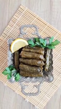Dekoratif bir tabakta pirinçle doldurulmuş üzüm yapraklarından yapılmış lezzetli bir Türk dolması.