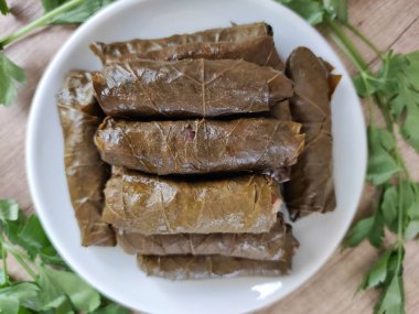 Dekoratif bir tabakta pirinçle doldurulmuş üzüm yapraklarından geleneksel Türk dolması