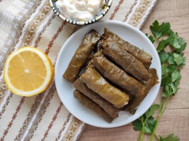 Dekoratif bir tabakta pirinçle doldurulmuş üzüm yapraklarından geleneksel Türk dolması