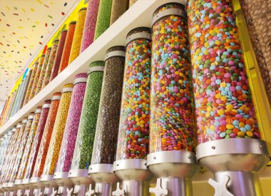 Vitrindeki cam kavanozlarla kaplanmış küçük yuvarlak şekerler.