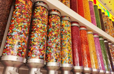 Vitrindeki cam kavanozlarla kaplanmış küçük yuvarlak şekerler.