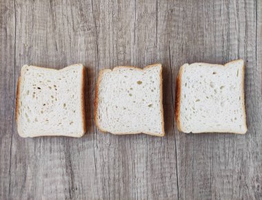 Kare beyaz ekmek parçaları ahşap bir zeminde