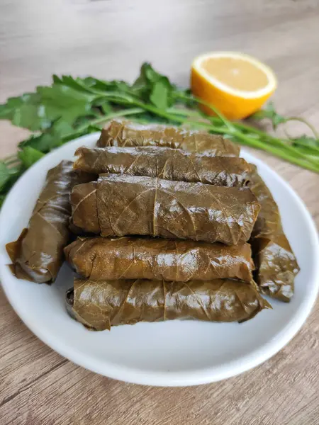 Dekoratif bir tabakta pirinçle doldurulmuş üzüm yapraklarından geleneksel Türk dolması