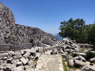 Roma döneminin eski bir harabe amfitiyatrosu. Taş duvarları, kolonları, kemerleri ve merdivenleri var.