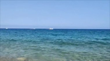 Güzel mavi Akdeniz dalgaları, ufukta süzülen gemiler