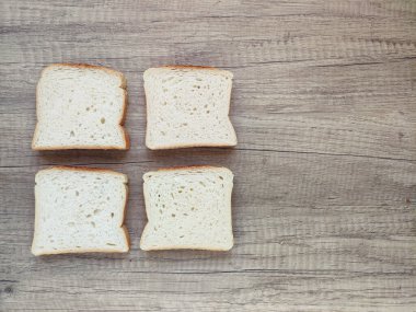 Kare beyaz ekmek parçaları ahşap bir zeminde