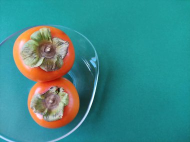 Yeşil yapraklı taze turuncu hurma.