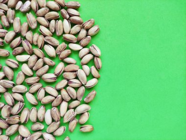 Yeşil arka planda taze kurutulmuş fıstık.
