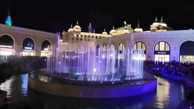 Antalya, Türkiye, 23 Eylül 2024. Parlak ışıklarla aydınlatılmış dans eden su jetleriyle akşam gösterisi. Parlayan renkleri ve büyüleyici su hareketleriyle büyülü bir atmosfer.