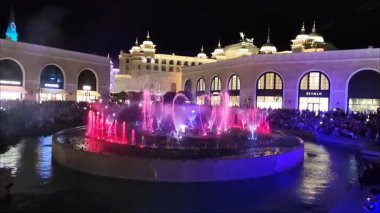 Antalya, Türkiye, 23 Eylül 2024. Parlak ışıklarla aydınlatılmış dans eden su jetleriyle akşam gösterisi. Parlayan renkleri ve büyüleyici su hareketleriyle büyülü bir atmosfer.