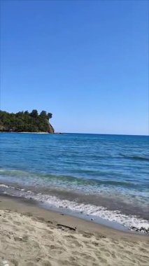  Akdeniz Körfezi 'nin manzarası. Dalgalarla mavi su, yazları yeşil bitki örtüsü olan bir sahil.