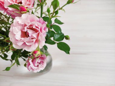 Açık arkaplanda pembe ve turuncu güllerden oluşan güzel bir buket.