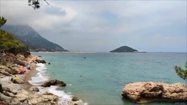 Akdeniz Körfezi 'nin manzarası. Dalgalarla mavi su, yazları yeşil bitki örtüsü olan bir sahil.