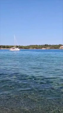 Mavi Akdeniz 'de beyaz bir zevk yatı. Resimli bir ormanın arka planına karşı.