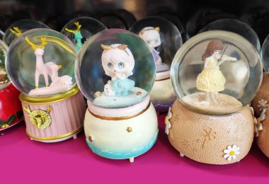 İçinde oyuncak olan şeffaf camdan bir kar küresi tezgahta, vitrinde. Ev için dekoratif iç dekorasyon.