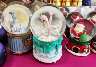 İçinde oyuncak olan şeffaf camdan bir kar küresi tezgahta, vitrinde. Ev için dekoratif iç dekorasyon.