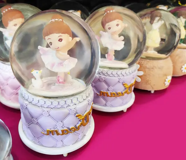 İçinde oyuncak olan şeffaf camdan bir kar küresi tezgahta, vitrinde. Ev için dekoratif iç dekorasyon.