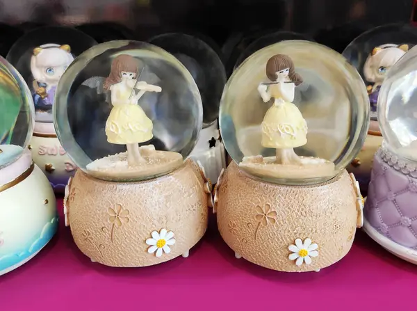 İçinde oyuncak olan şeffaf camdan bir kar küresi tezgahta, vitrinde. Ev için dekoratif iç dekorasyon.