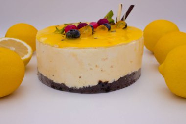 Çikolatalı bisküvi tabanlı lezzetli limonlu pasta ve böğürtlenlerle süslenmiş. Yan görünüm.