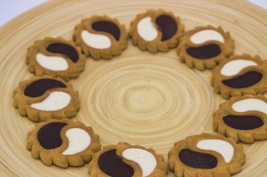 Yarım ay şeklinde, ahşap tabakta çift renkli kremalı kurabiyeler.