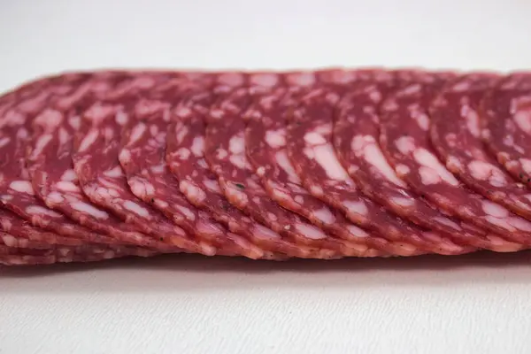Artisanal salami slices fanned out on rustic wood