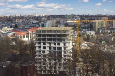Şehir manzarasında vinç olan yüksek bina yapım aşamasında..