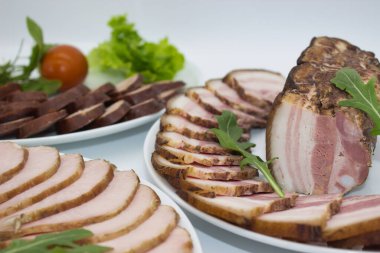 Taze marul ve sarımsak ile sunulan yumuşak, dilimlenmiş domuz eti. Domuz etinin zengin, dumanlı tadı gevrek yeşilliklerle tamamlanır. Bu da onu her yemek için mükemmel bir süs yapar..