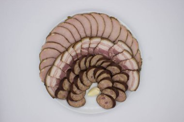 Taze domuz eti, tuzlu pastırma ve zengin sosis de dahil olmak üzere dilimlenmiş et çeşitlerinin yer aldığı güzel düzenlenmiş bir tabak. Toplantılar için mükemmel, bu çeşitlilik farklı tat ve dokuları bir araya getirip, enfes bir tat yaratıyor.