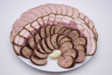 Taze domuz eti, tuzlu pastırma ve zengin sosis de dahil olmak üzere dilimlenmiş et çeşitlerinin yer aldığı güzel düzenlenmiş bir tabak. Toplantılar için mükemmel, bu çeşitlilik farklı tat ve dokuları bir araya getirip, enfes bir tat yaratıyor.