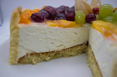 Lezzetli bir katmanlı meyveli pasta sulu üzümler, kirazlar ve kadınsı parmaklarla çevrili bitki salatası. Taze meyve, kremalı dokuya biraz renk ve keskin bir zıtlık ekler..