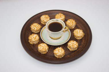 Zarif bir fincan sade kahve ve kremayla dolu mini fındıklı kurabiyeler. Sıcak bir kahve molası ve gurme ikram için mükemmel..